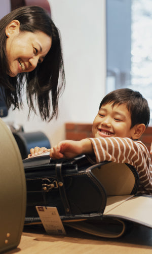 黒いランドセルを開ける子ども