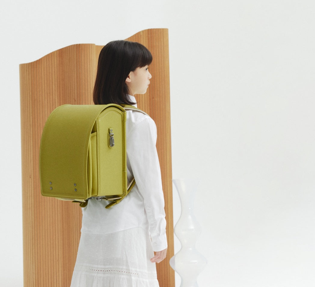 RECOの2027年新色ランドセルのプリズムオリーブイエローを背負った子供