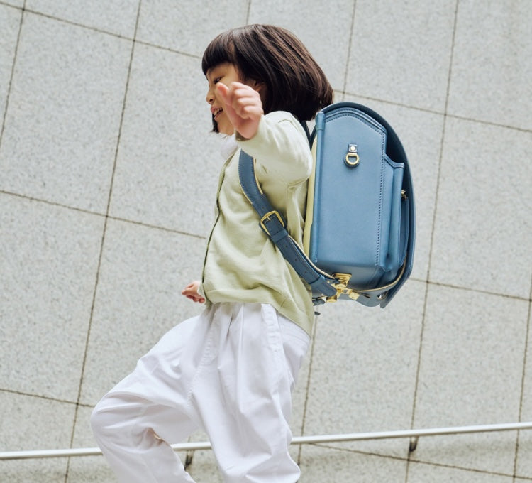 水色のランドセルで軽やかに飛ぶ子供